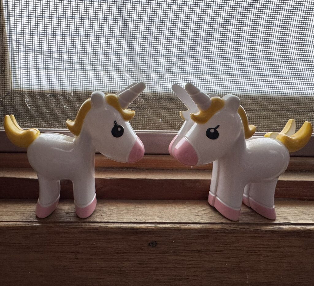 two unicorn clips on a window sill